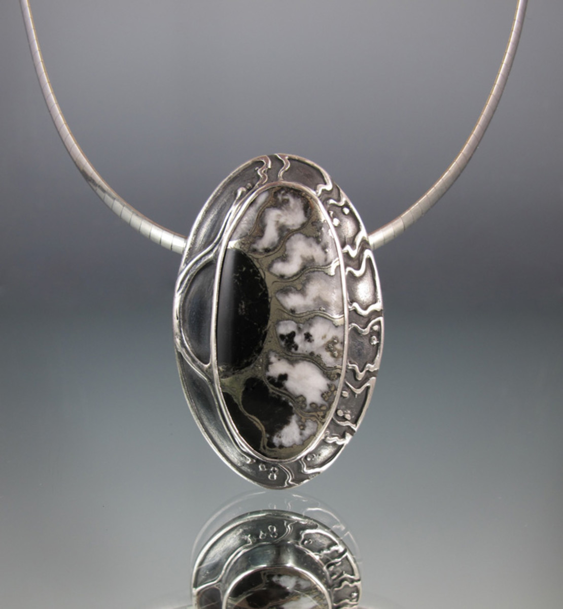 For this pendant, Lisa extended the distinctive patterns in an ammonite fossil cabochon stone onto the backplate of the silver metal clay bezel setting.
