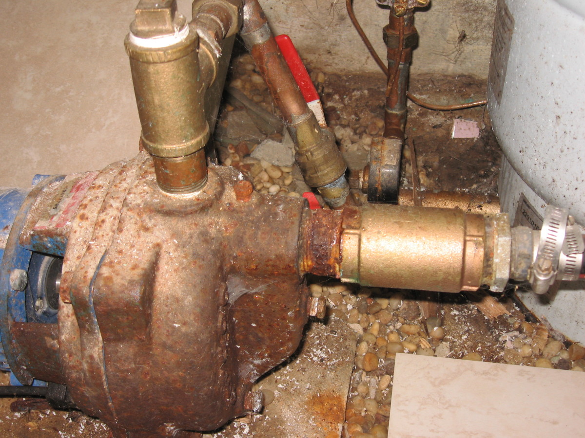 The brass check valve in this photo is on the right side of the water pump. This is where the main water supply enters the pump from the line running from your newly driven well point.