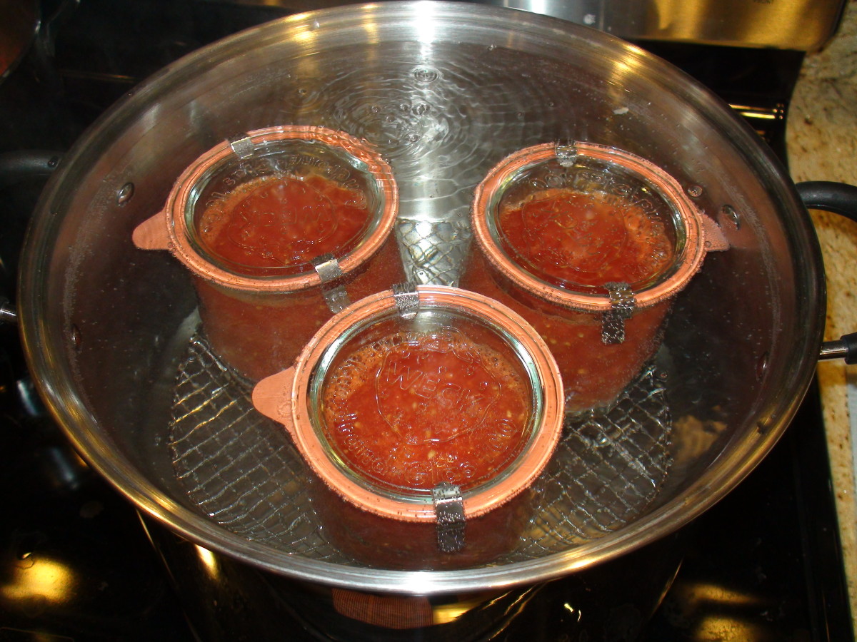 Roma tomatoes being preserved in a boiling water bath in Weck canning jars.