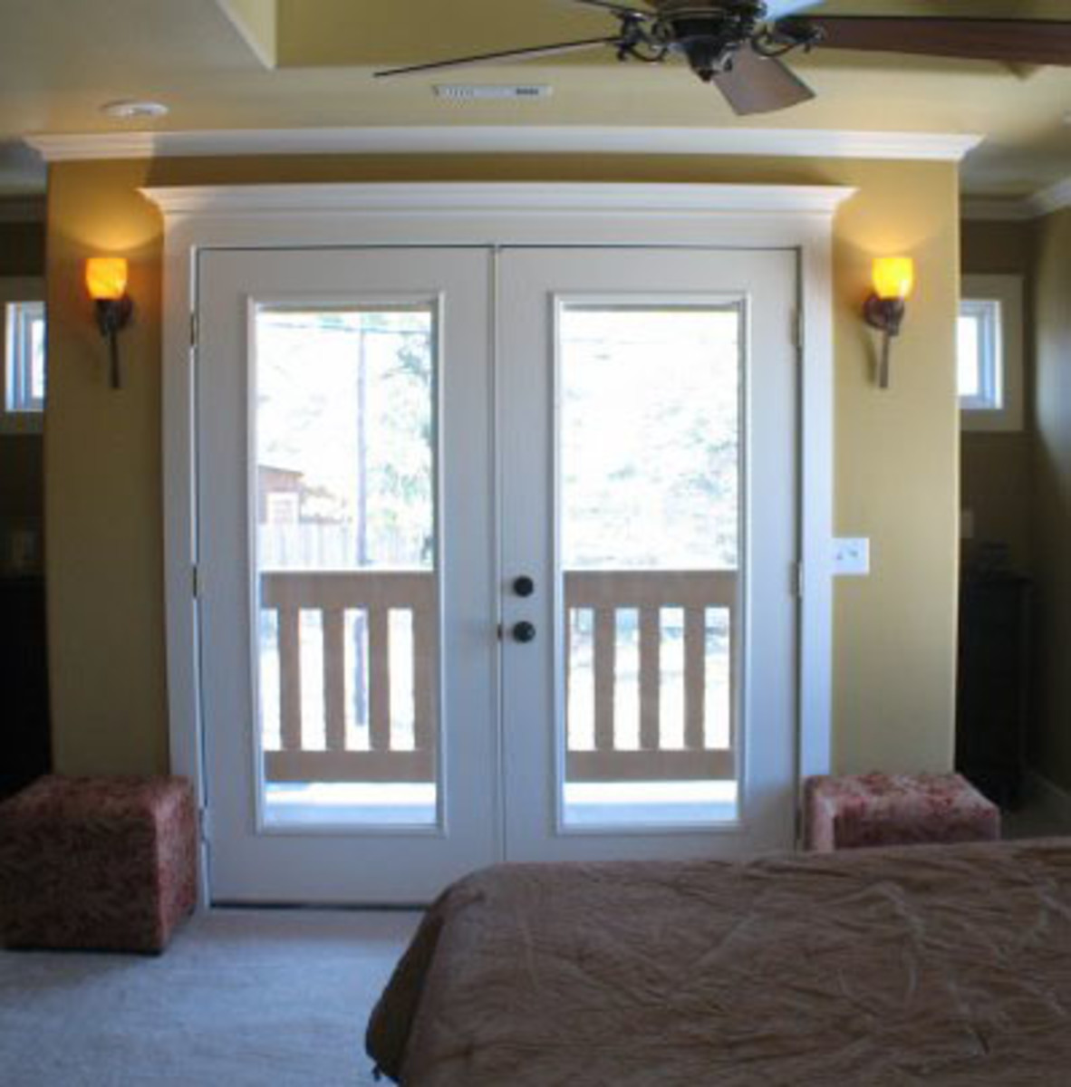 Double doors leading to balcony from master suite.  A second floor master suite was added on. Rather than extending the room the full length of the garage below, a few feet were stolen for a private balcony accessed via french doors.