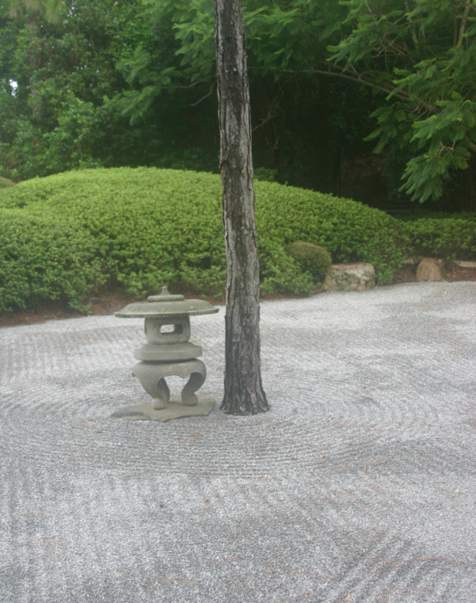 This early waterless, or dry Japanese garden already has the patterned, raked stones of the Zen garden. But the ornament is carved stone, not natural rock, and there is still a tree in the garden.