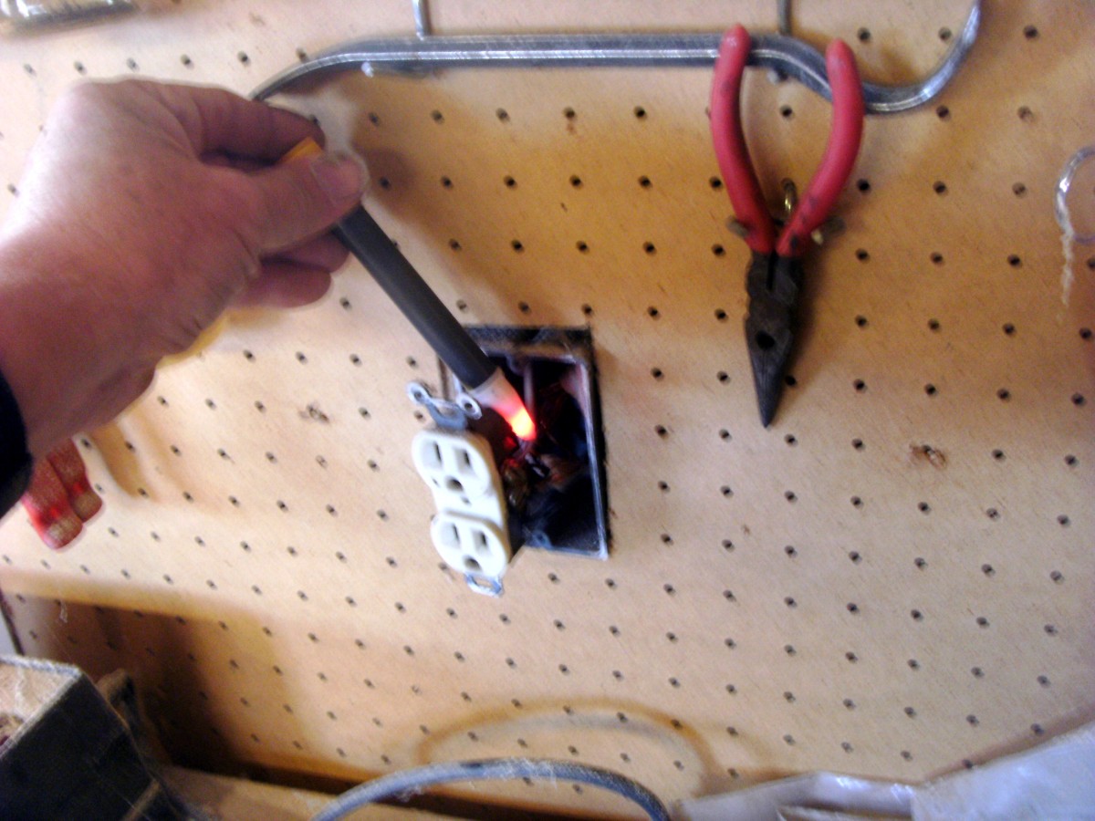 This outlet mounted through a pegboard wall is still hot, and a very good example of why to use a tester.  It was supposed to be turned off.