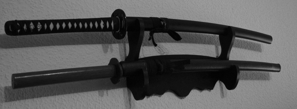 Katana and bokken in saya, displayed on a wall-mounted stand.