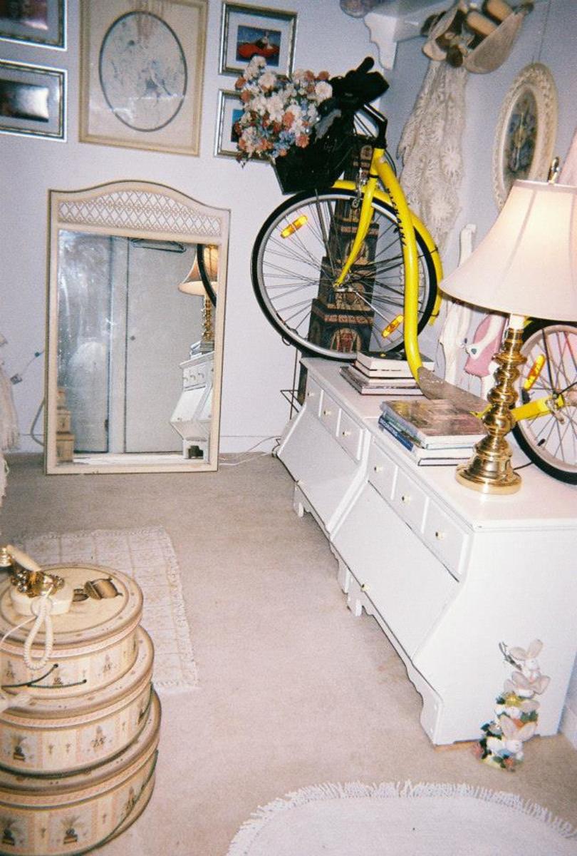 Four bunnies form a totem pole at the lower right. Three graduated hat boxes are stacked to use as a night stand. The gold and white dial phone works! The most expensive item in the picture/room above is the yellow 'bike'—it's a kickbike!