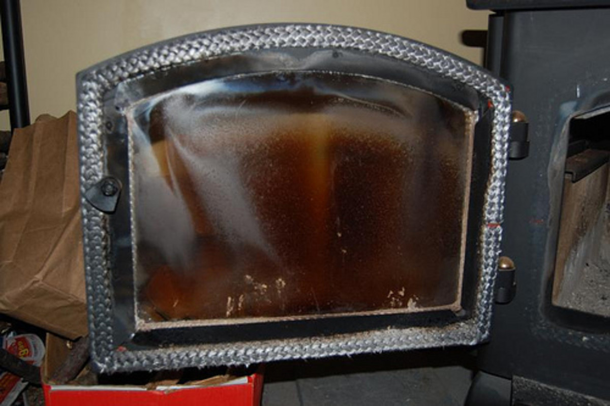 Does the glass on your wood stove or fireplace look like this? Read on to find out how to remove this film!