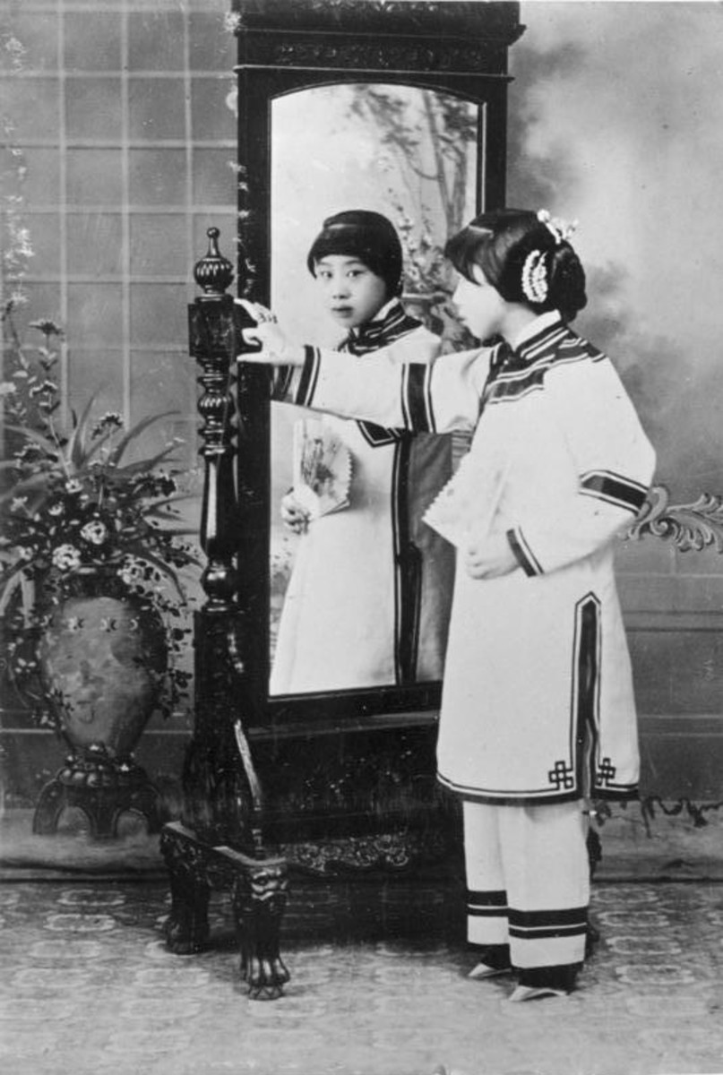 Chinese woman in traditional dress in front of mirror.