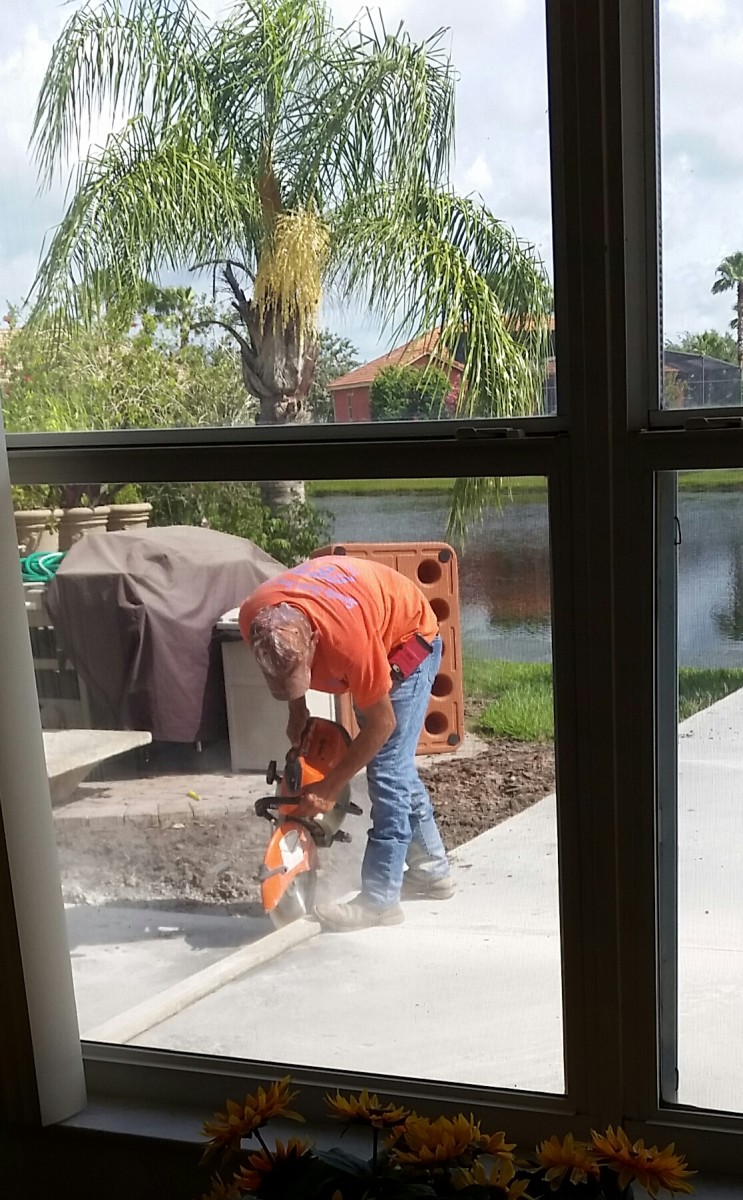 I didn't find out what the purpose of this was. The worker came the day after the pour to measure out a grid on the pavement. Then he cut along that grid (about 1 inch deep). My guess is that these allow for contraction and expansion of the concrete.