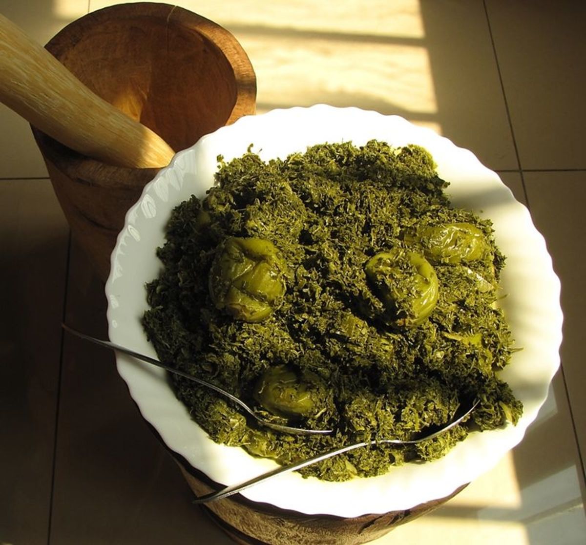 An African dish called saka saka that is made with unripe pumpkin on a stick and pounded cassava leaves.