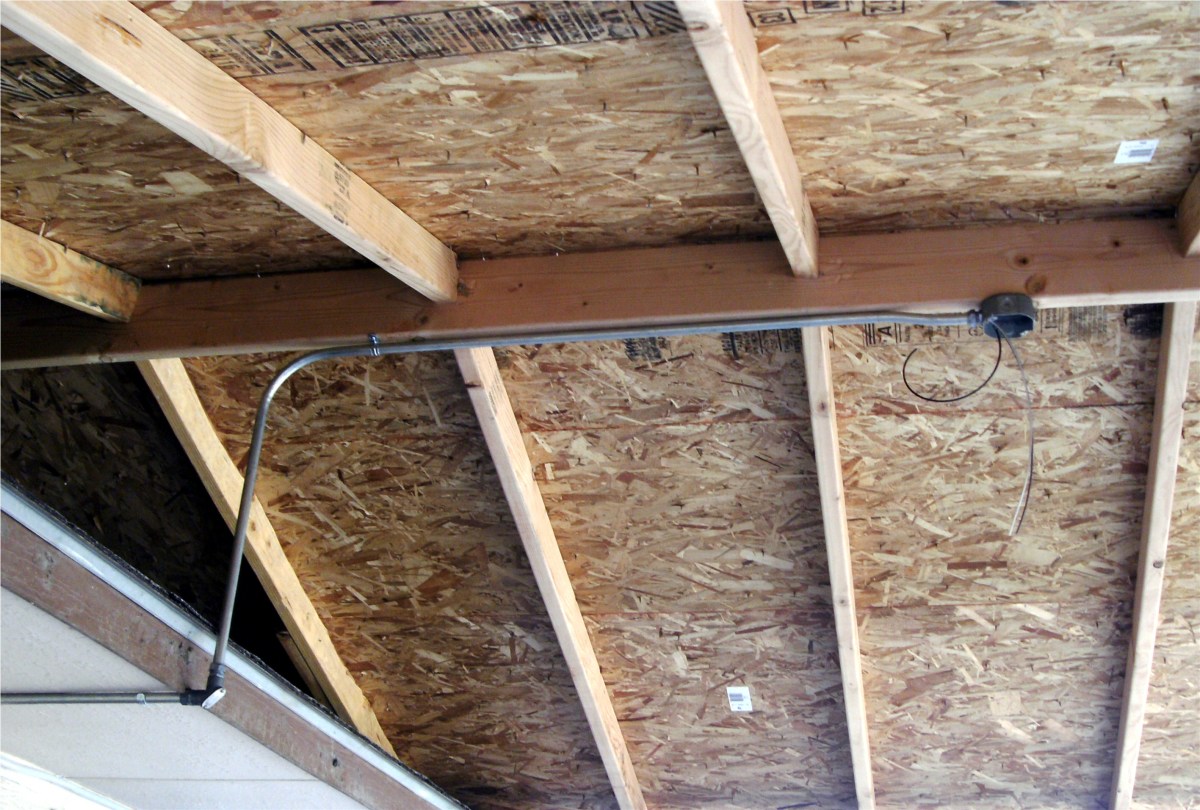 Metal box mounted on the ridge of a covered patio for installation of an outdoor ceiling fan. 