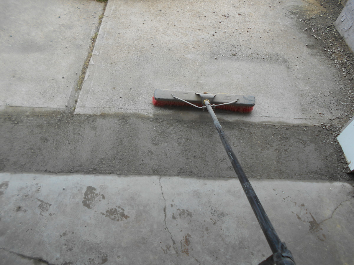 finishing the concrete slab with a broom
