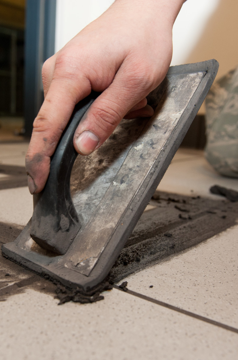 Hold the grout float at a 45-degree angle and apply downward pressure.