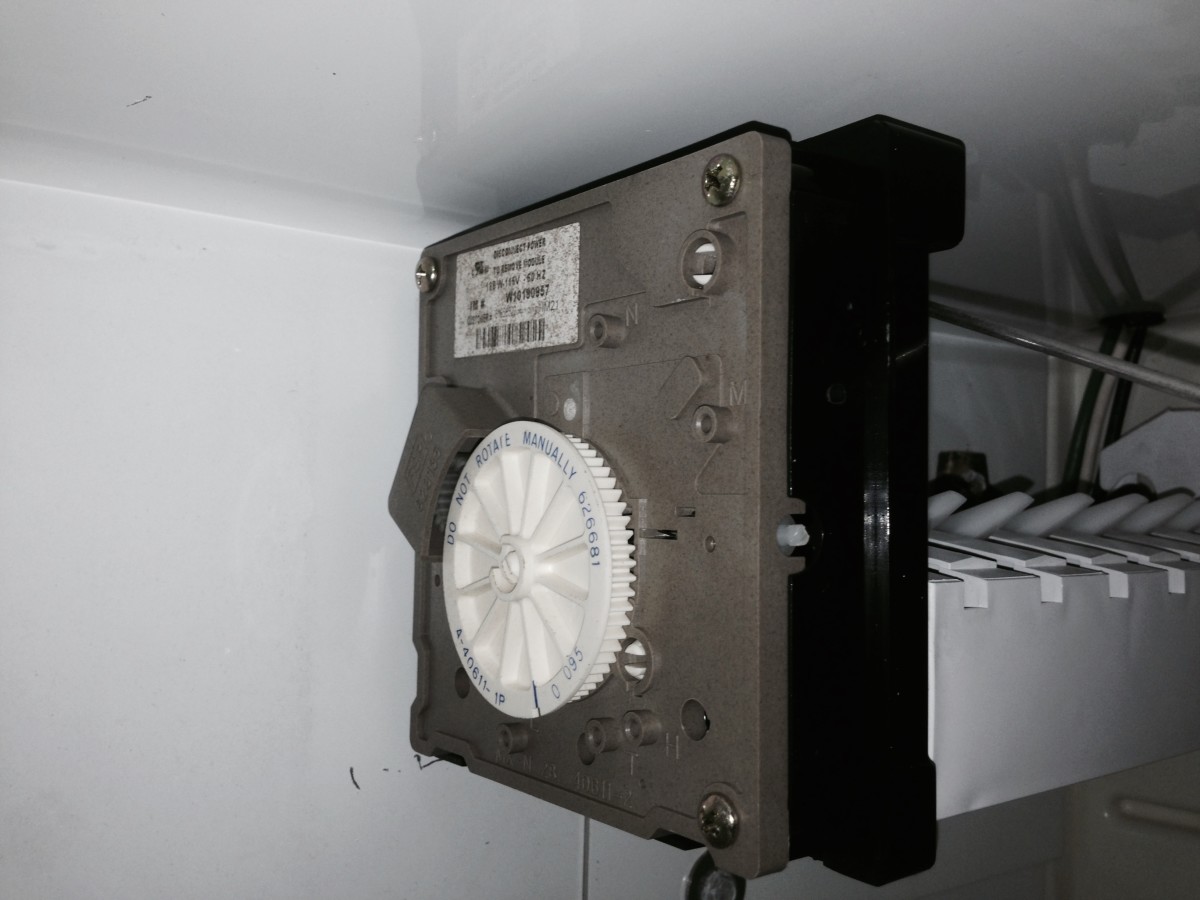 A side view of the controls on ice maker with the cover removed and showing the label.