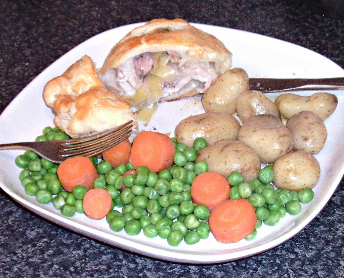 Leek and bacon stuffed chicken thigh en croute with new potatoes, carrots and peas