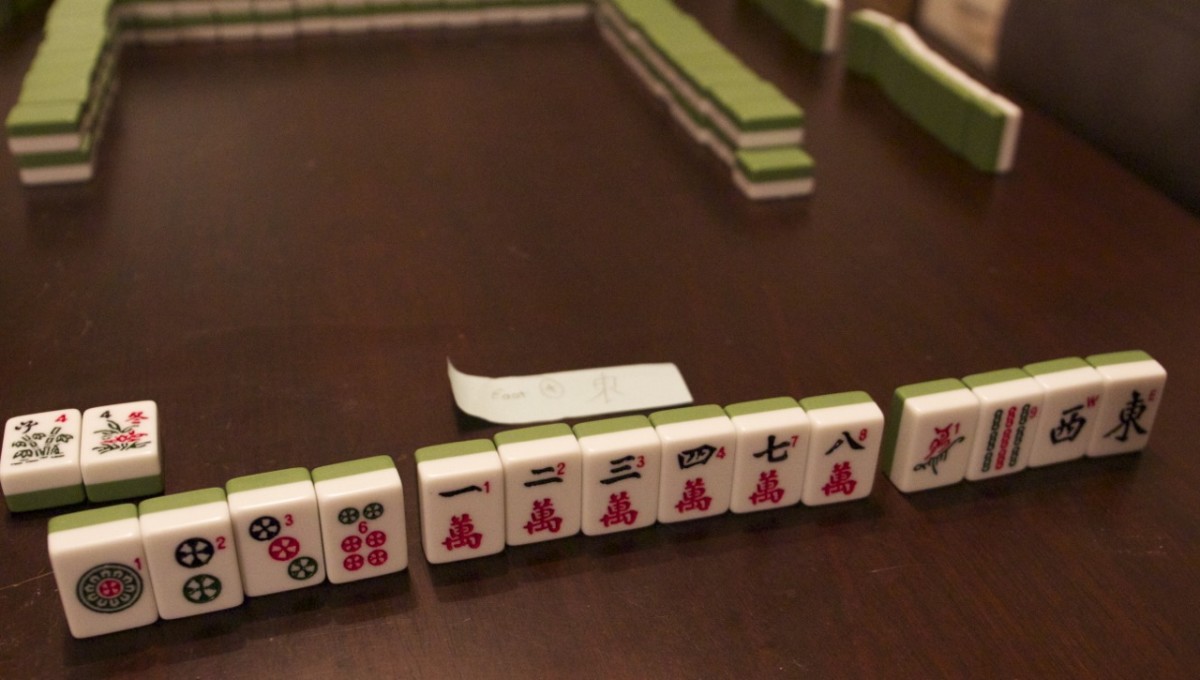 An opening hand in three player mahjong, with a couple of chi melds and two special tiles.