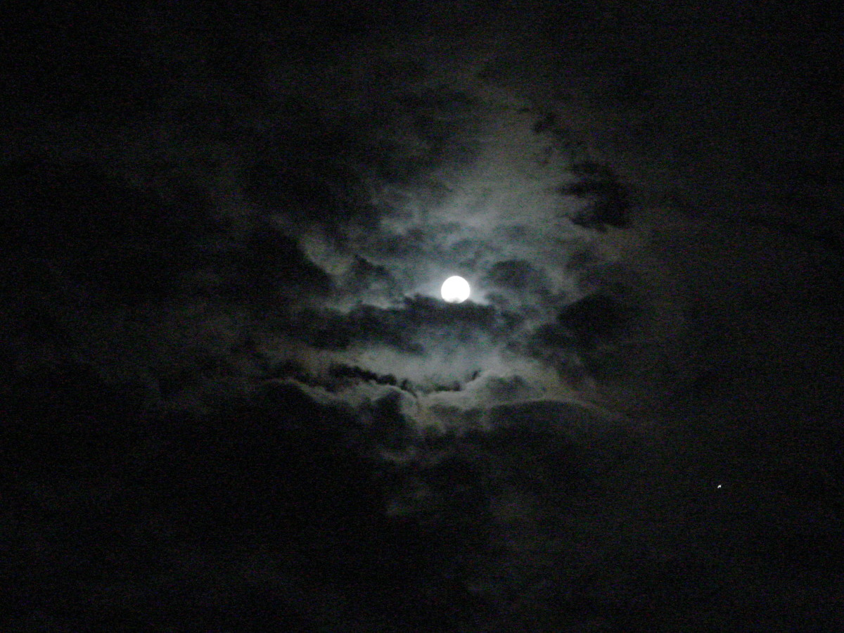 Full moon surrounded by clouds over Carmel-by-the-Sea, California