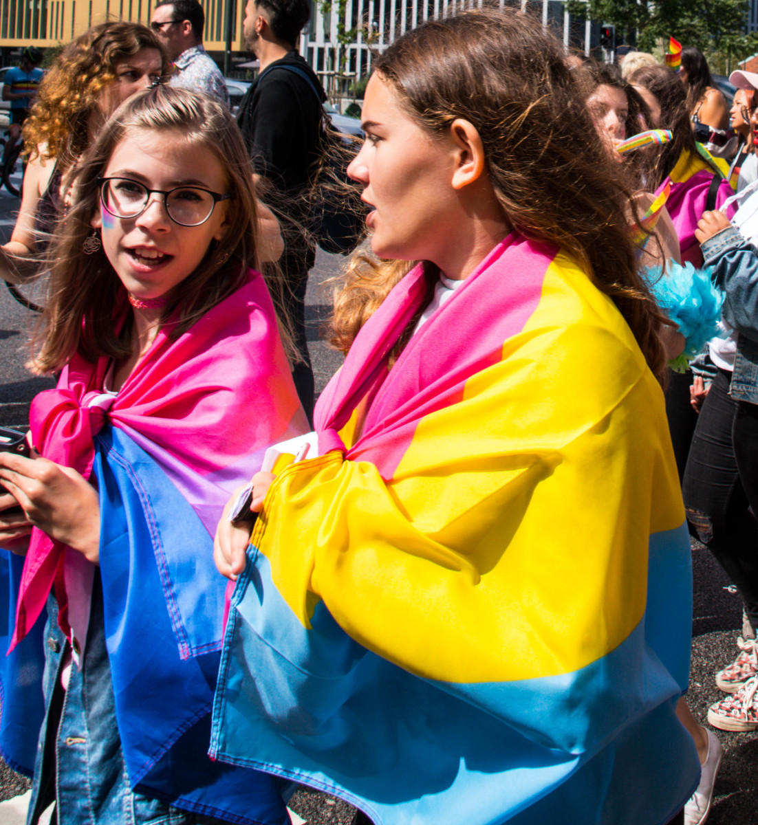 A girl wearing a bi pride flag and a girl wearing a pan pride flag at a pride festival. Malmö, Sweden 6 August 2017
