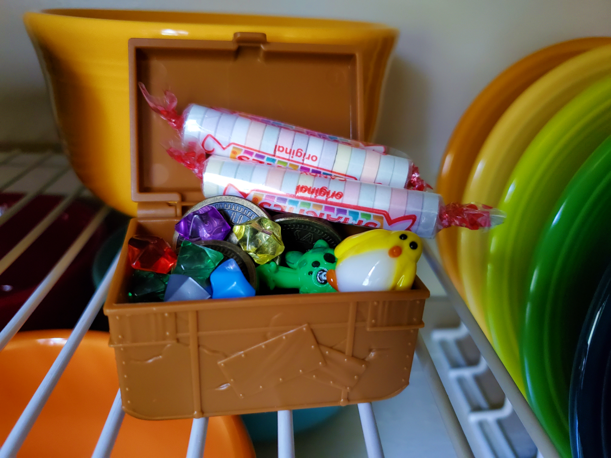 The treasure was in the dish cupboard all along. Fake coins and gems, small  toys, and candy all make fun loot ideas for kids. Little treasure chests are a great way to present the loot, especially if you're doing a pirate-themed hunt.