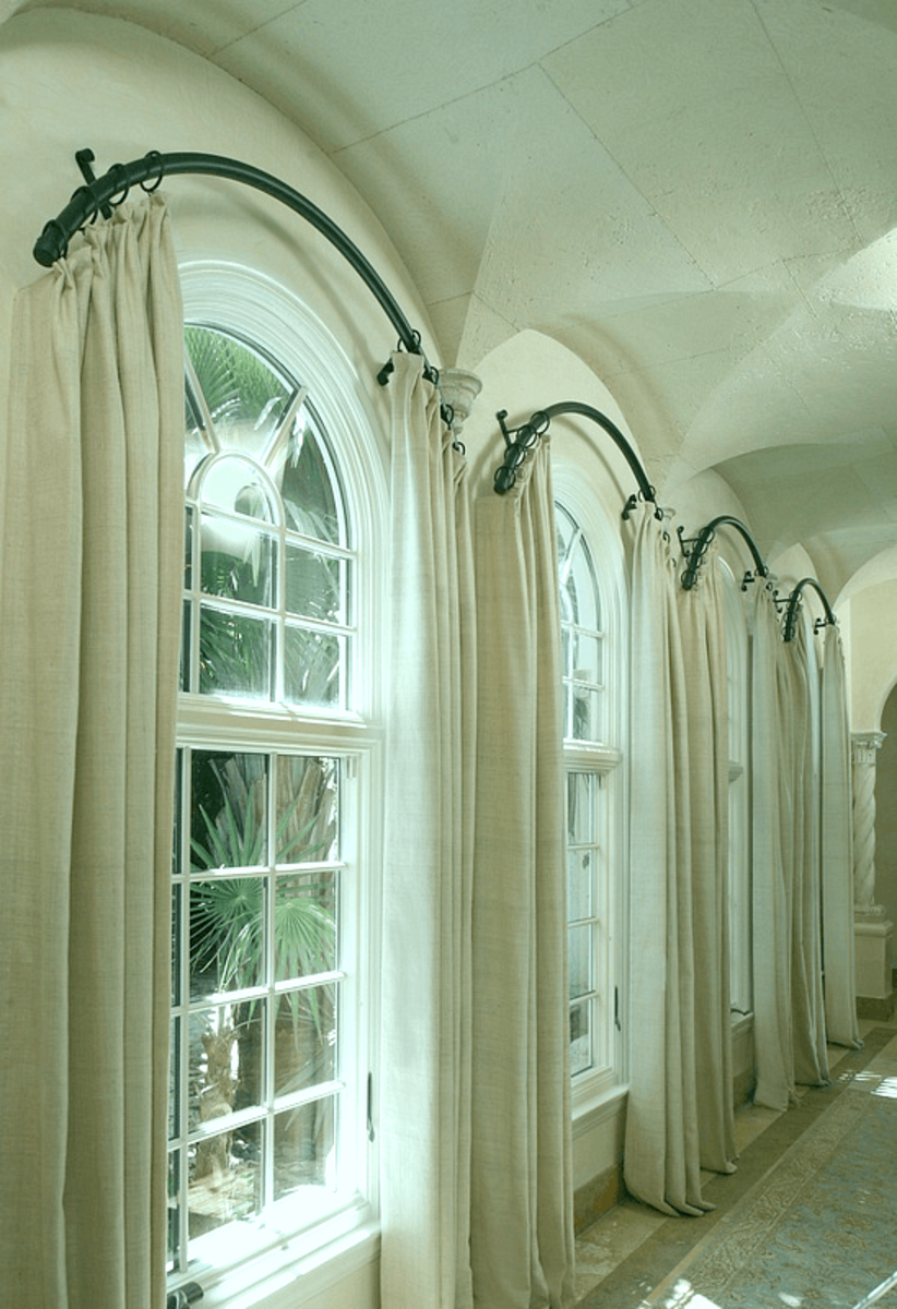 Curved curtain rods installed outside of the arch create a striking look.