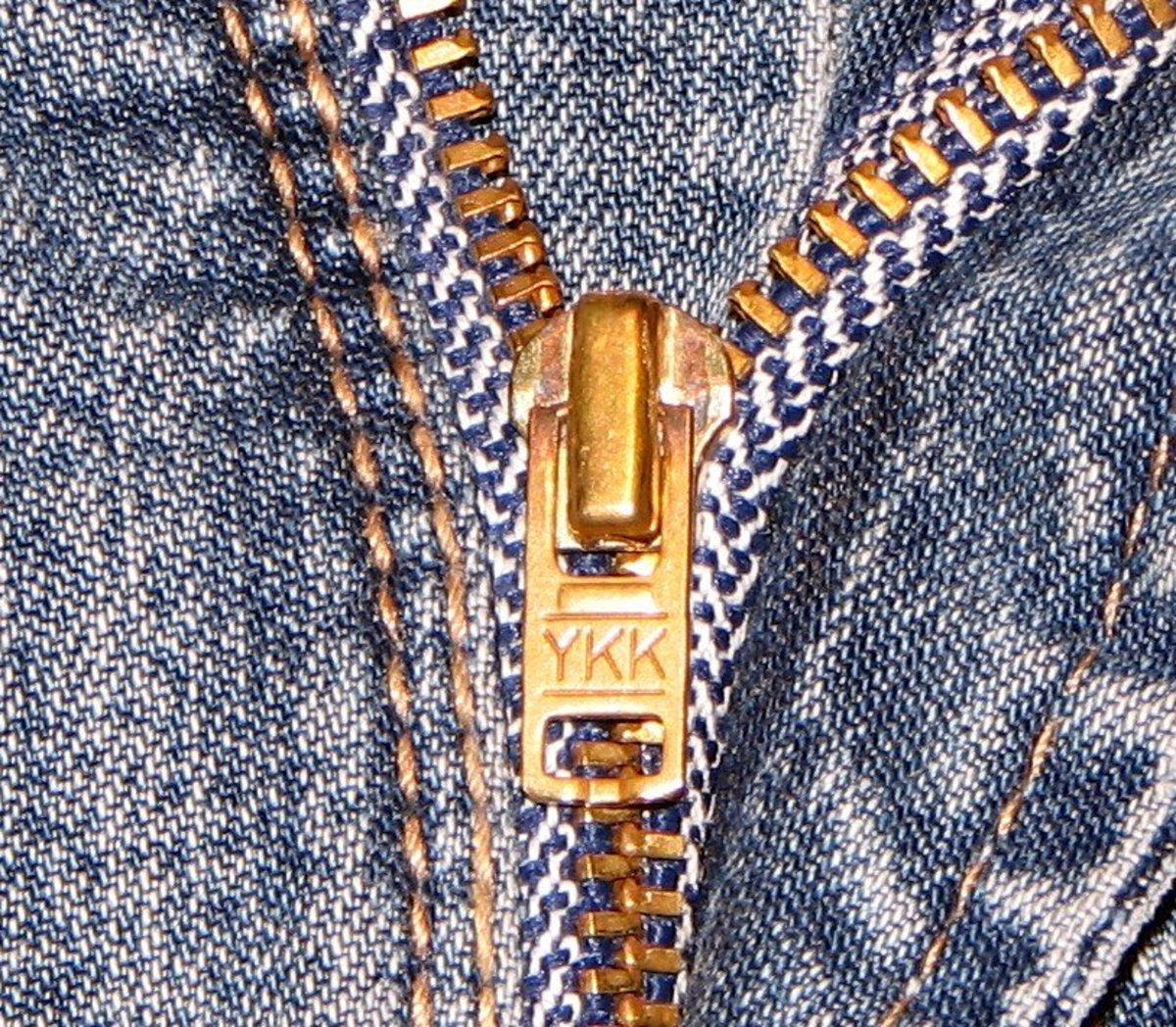 Various denim brands of clothing feature brass zippers and buttons.