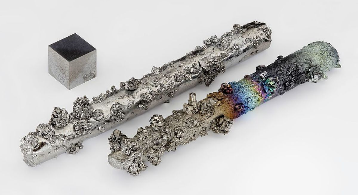 By Alchemist-hp (talk) (www.pse-mendelejew.de) - Tungsten rods with evaporated crystals, partially oxidized with colorful tarnish. Purity 99.98 %, as well as a high pure (99.999 % = 5N) 1 cm3 tungsten cube for comparison.