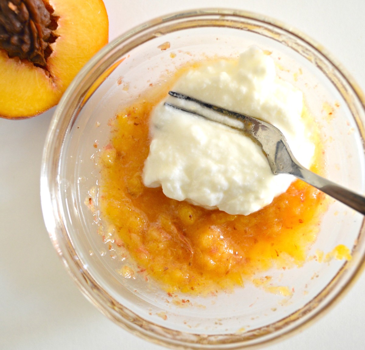 Mix yogurt and mashed peach  together in a bowl with a fork.