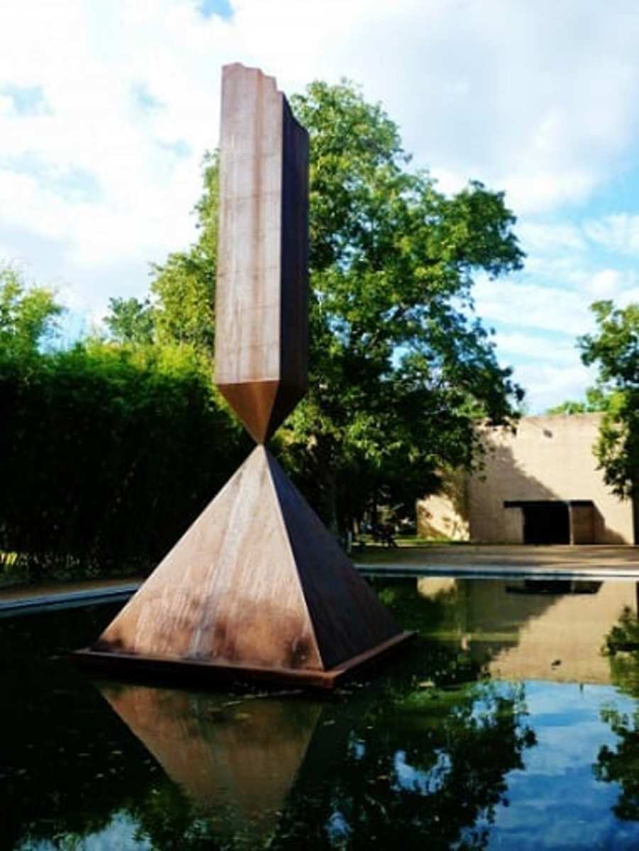 Photo of the "Broken Obelisk" in a reflection pool outside of the Rothko Chapel in Houston, Texas.