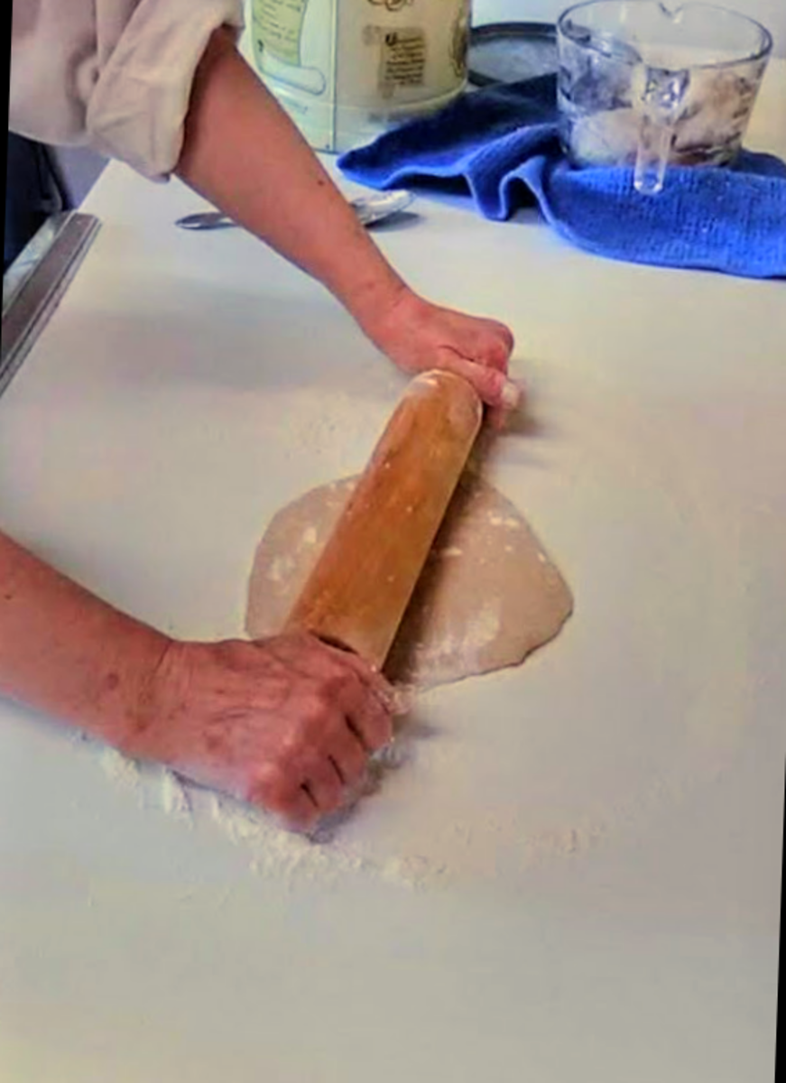 With the rolling pin of your choice, start in the middle of the flattened ball, and work outward, aiming for whatever shape will fit your pan(s).