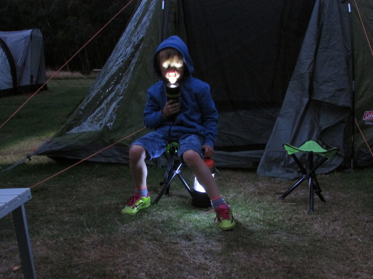 Making spooky faces with the torch during a family camping trip