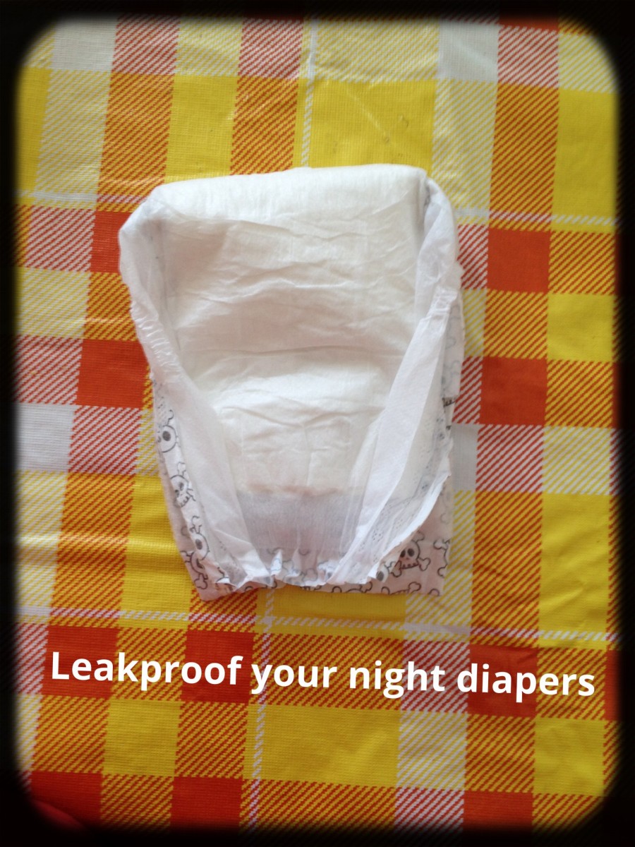 Fold smaller diaper in half with absorbent side out.