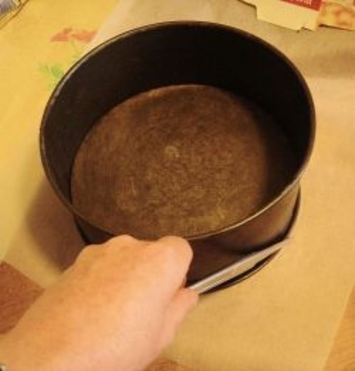 Marking the base of the cake tin with scissors.