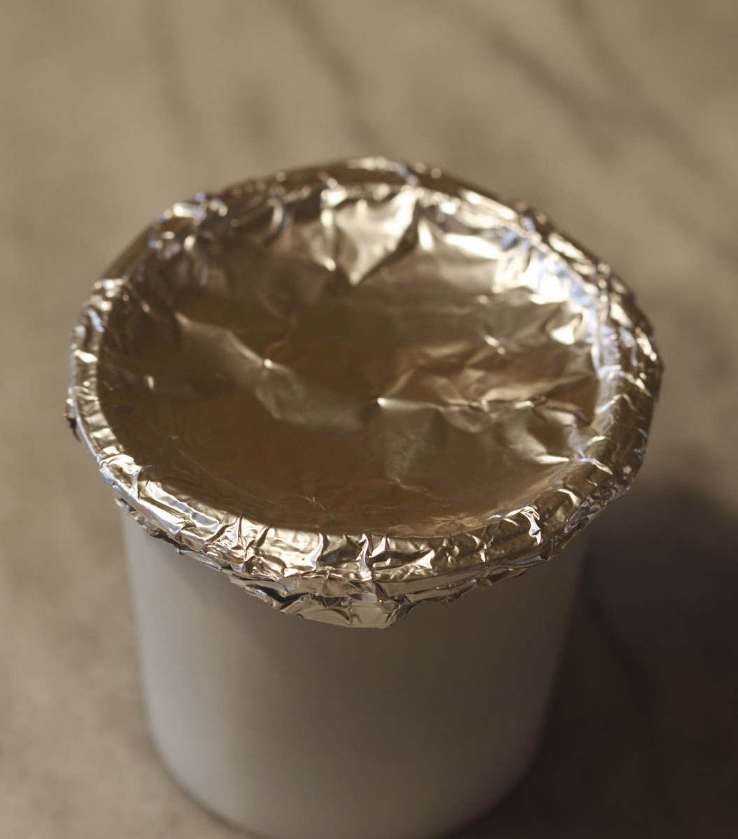 A covered and crimped reused K-cup.