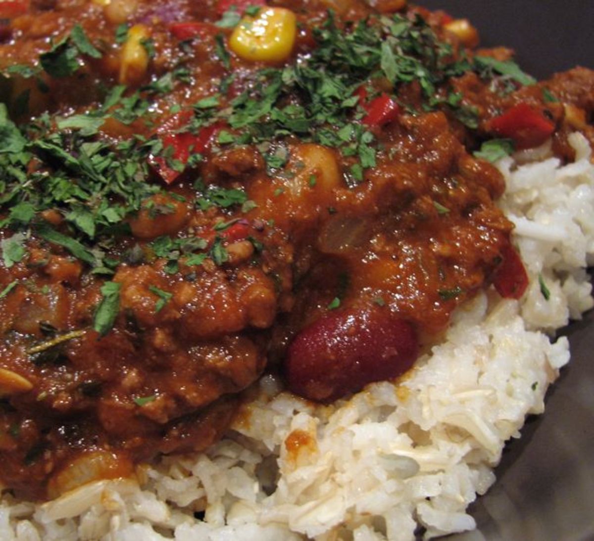 Mexican chili on rice, with corn, kidney and white beans, capsicum, carrot and cucumber.