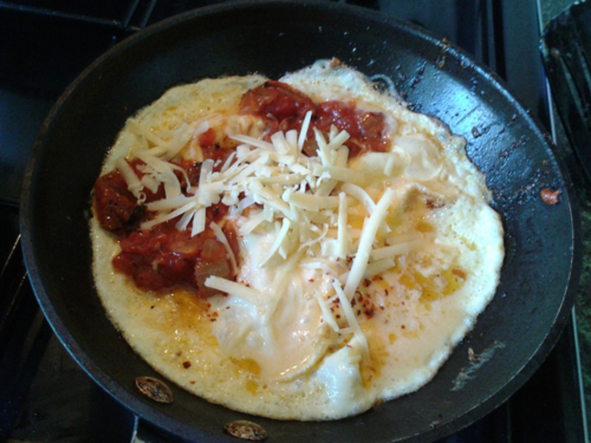 Omelette in the pan with cheese, tomato and onion