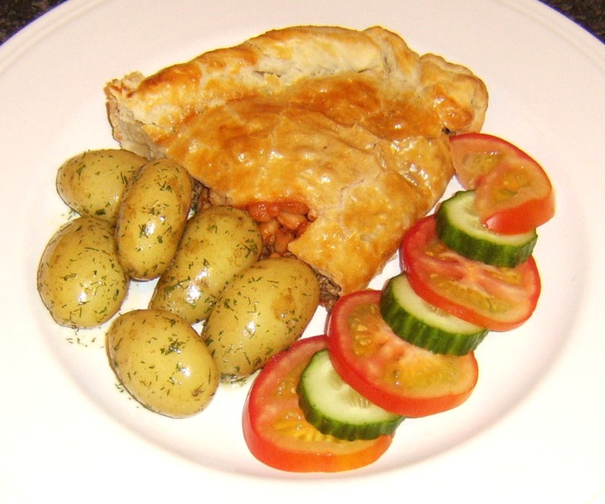 Half a baked beans and beef pasty, served with dill buttered new potatoes and salad