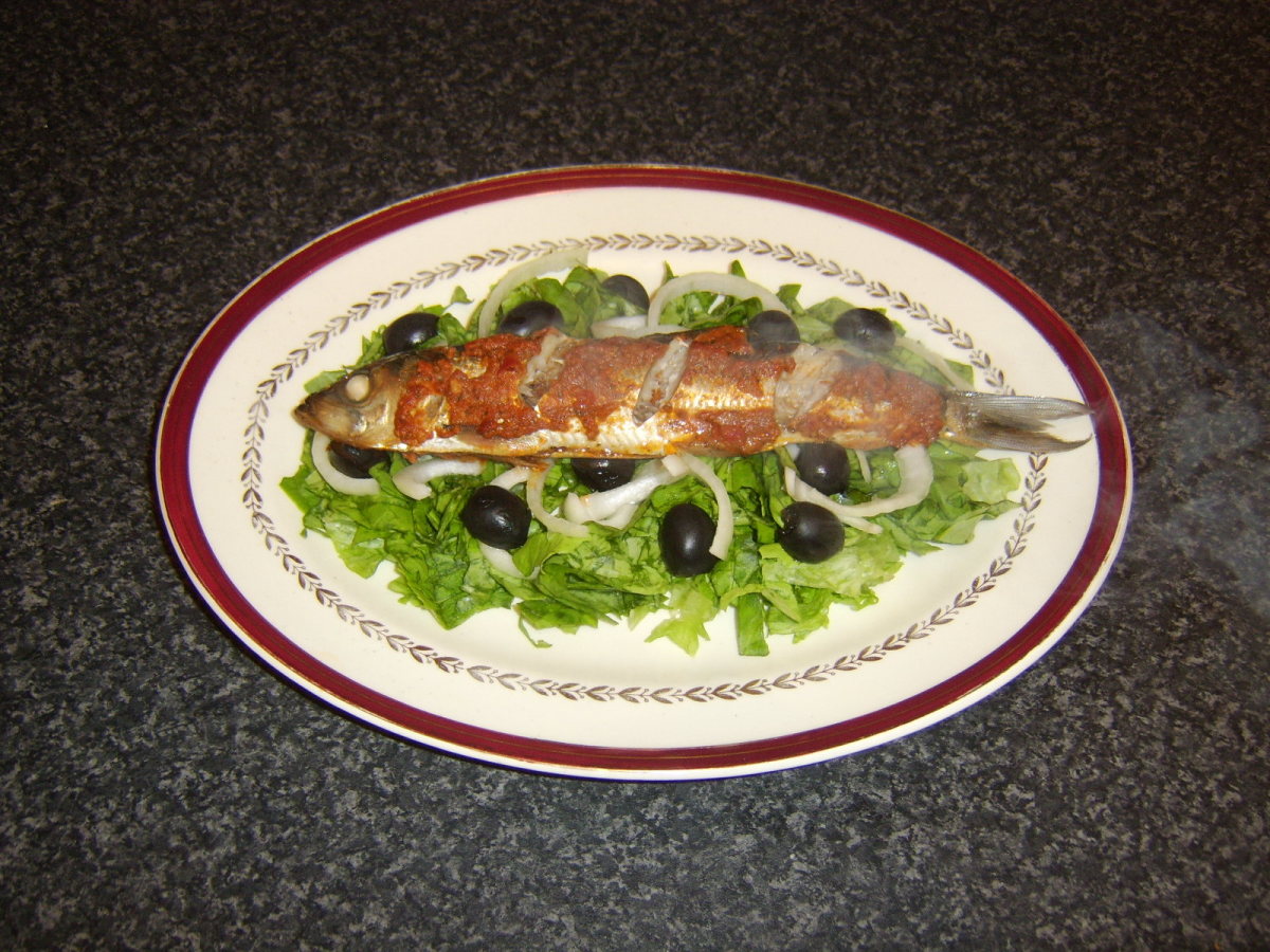 Red pesto sauce is spread on a herring before it is baked in the oven.
