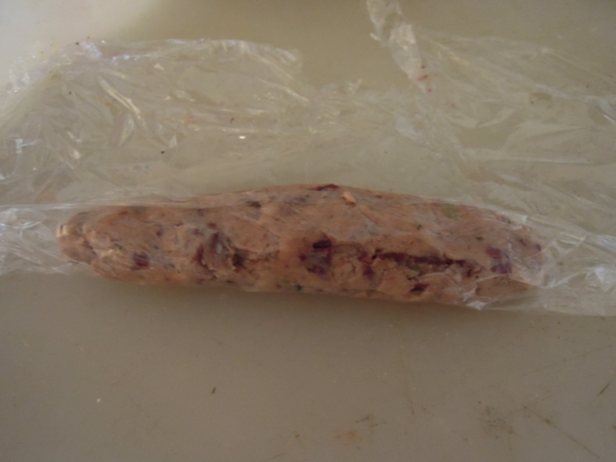 Use the plastic wrap to roll the sausage. This should help shape it further. 