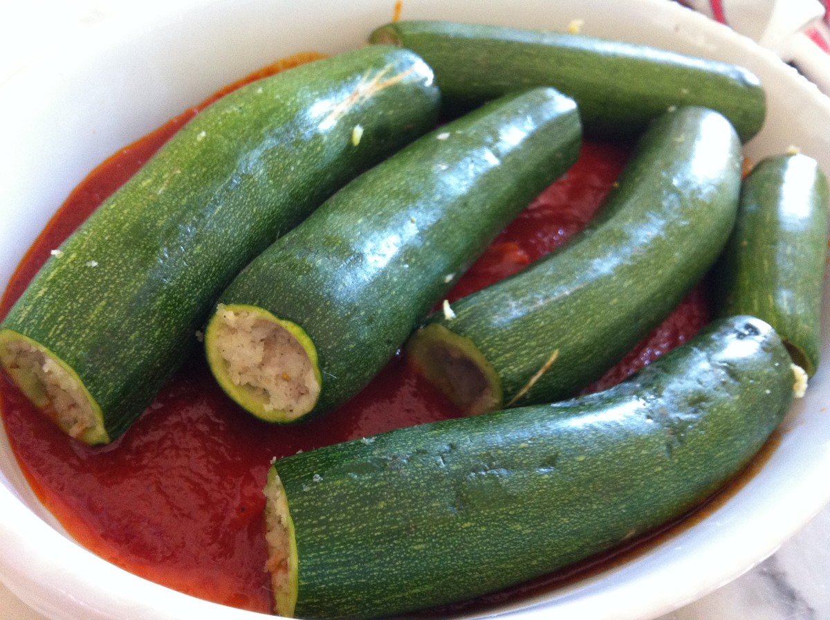 Zucchinis all fit in the dish with the tomato, wine sauce. They're ready to be baked.