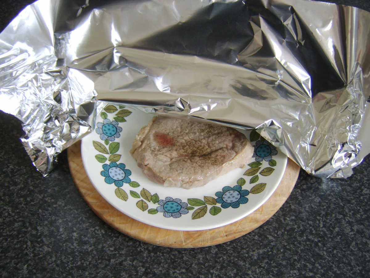 Resting a steak on a warm plate, covered with tinfoil