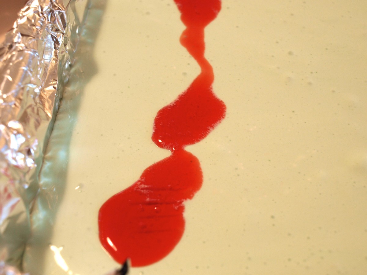 1. After the cherry gelatin is ready, add spoons of it on the top of the cheesecake.
