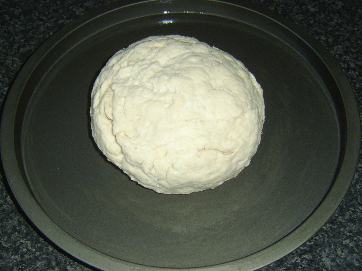 Soda bread dough is rolled in to a ball and laid on baking sheet.