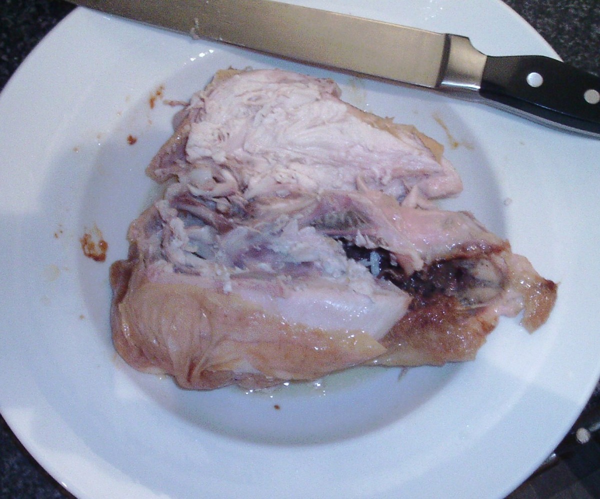 Chicken breast fillets are sliced free with a carving knife