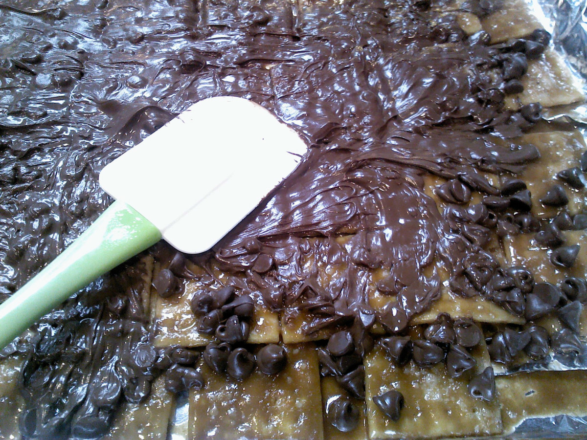 Spreading the melted chocolate over the crackers