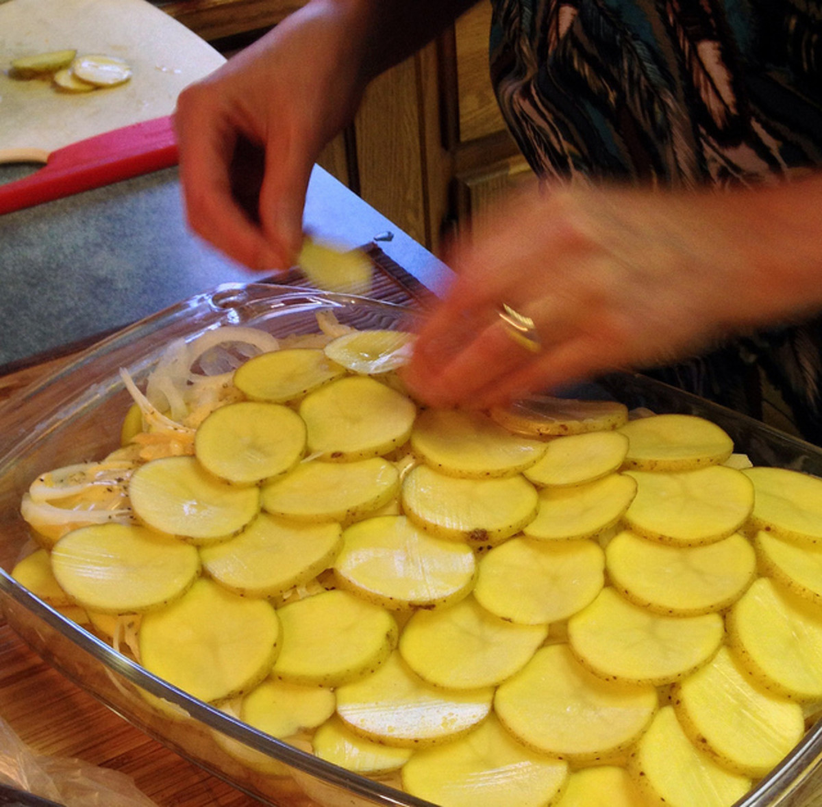 Layer the sliced potatoes in the baking dish