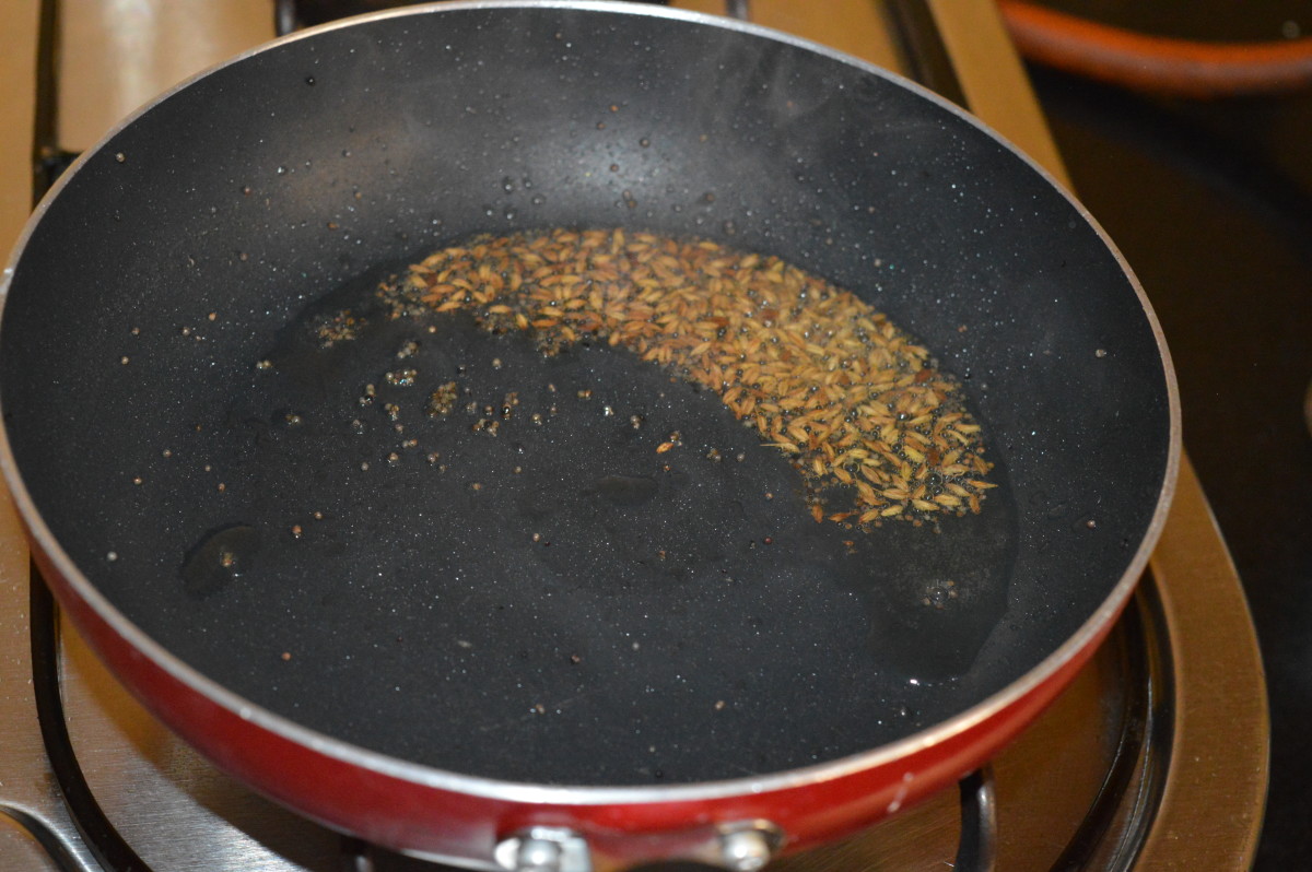 Step three: Heat oil in a deep-bottomed pan. Add mustard seeds. Let them crackle. Add cumin seeds. Make them sizzle.