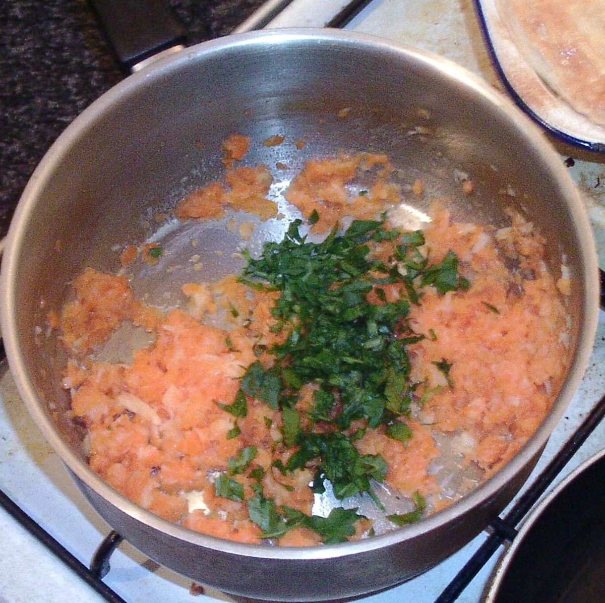 Chopped parsley is added to mashed carrot and parsnip