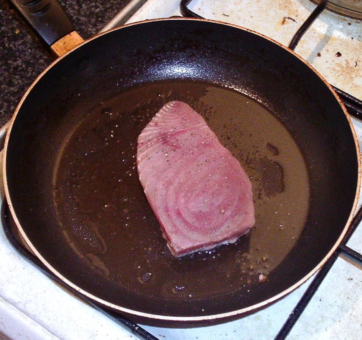 Tuna fillet is added to searingly hot frying pan
