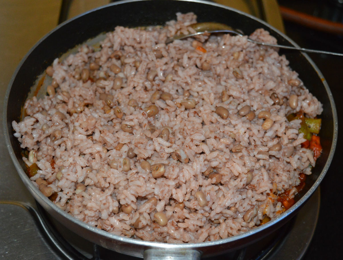 Step six: Add cooked rice-beans mix. Blend it with the contents in the pan. Next, turn off the heat.