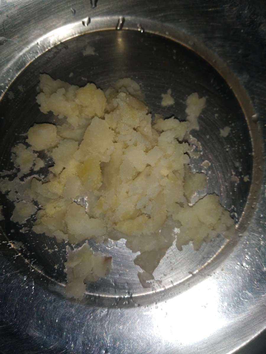 From boiled peas and potato mixture, take some portion of potato (about 1/4 portion), mash it, and set it aside.