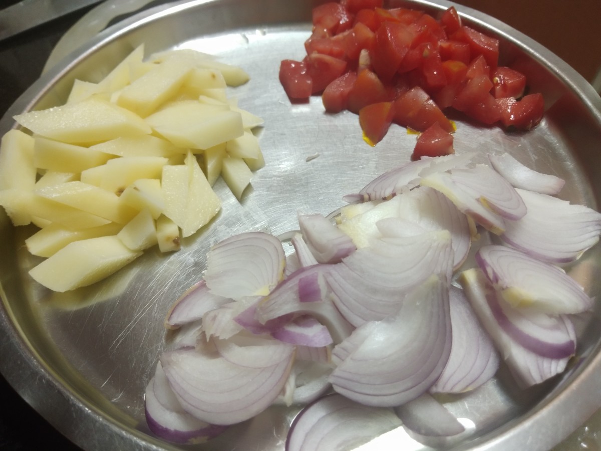 Slice onions, wash and chop tomatoes, peel and cube potatoes. Set aside.
