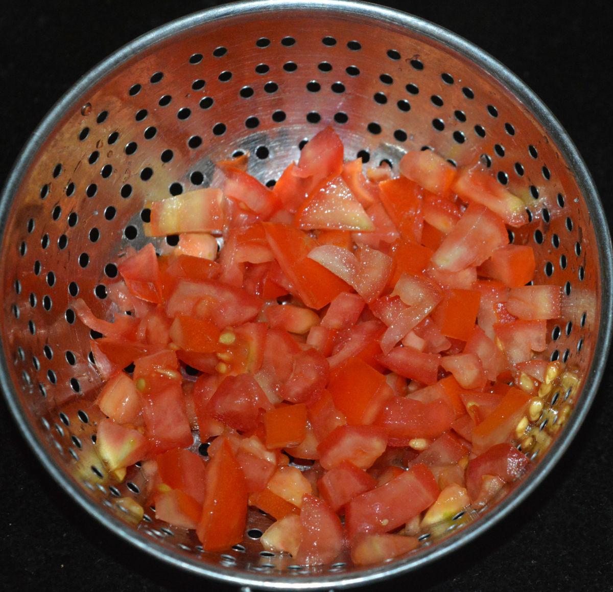 Step one: Finely chop the tomatoes. Place them in a colander. Apply salt. After 5 minutes, pour water over them in order to wash away the seeds. Set aside.